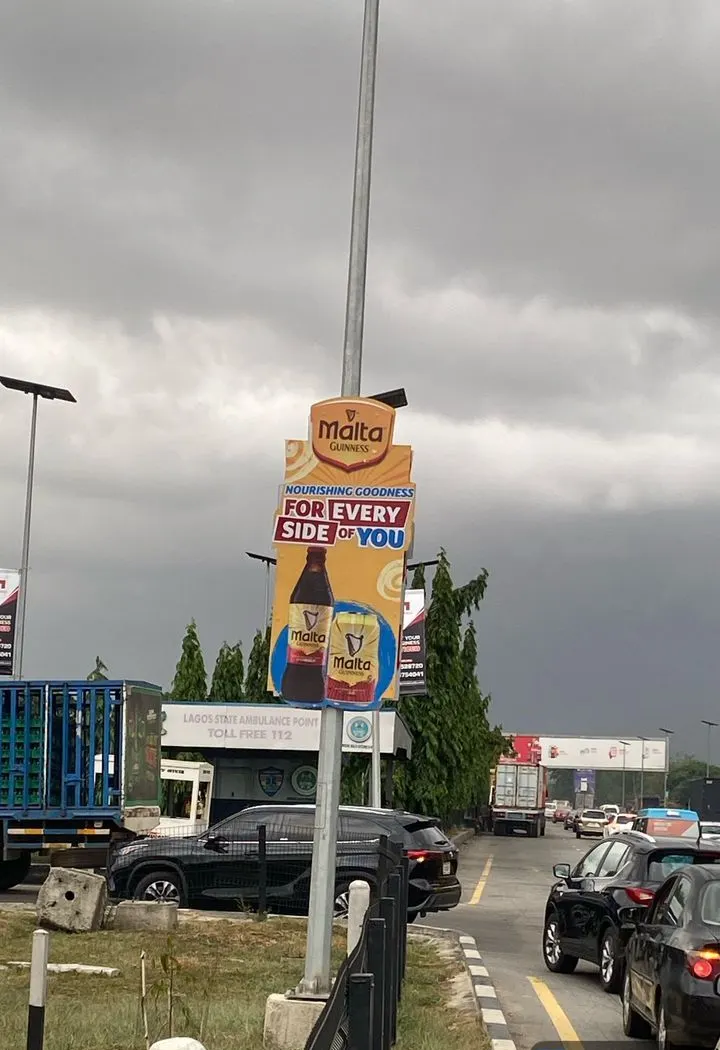 Malta Guinness bottle die cut on a roadside pole in Kosofe, Lagos